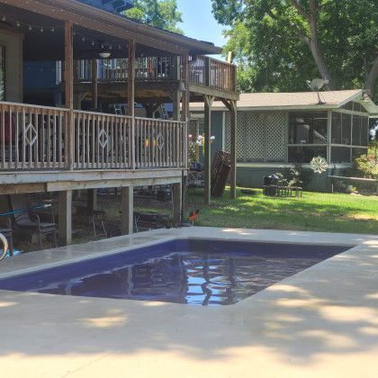 There is a large swimming pool in front of a house.