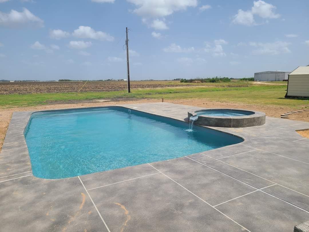 A large swimming pool with a hot tub in the middle of it.