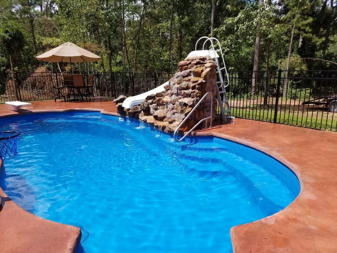 There is a water slide in the middle of the pool.