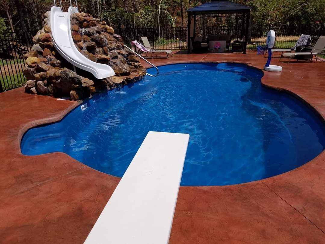 A large swimming pool with a slide and diving board
