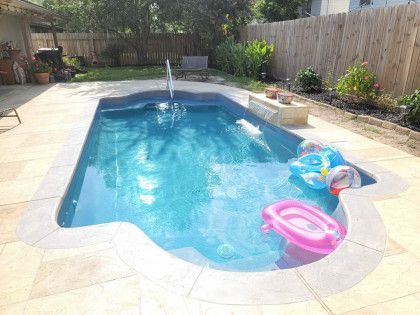 A large swimming pool with a pink flamingo float in it.