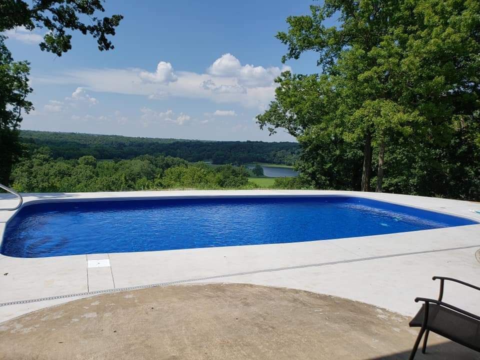 A large swimming pool with a view of a lake