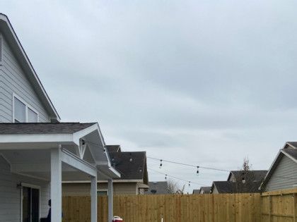 A house with a wooden fence in front of it.