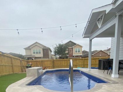 There is a swimming pool in the backyard of a house.