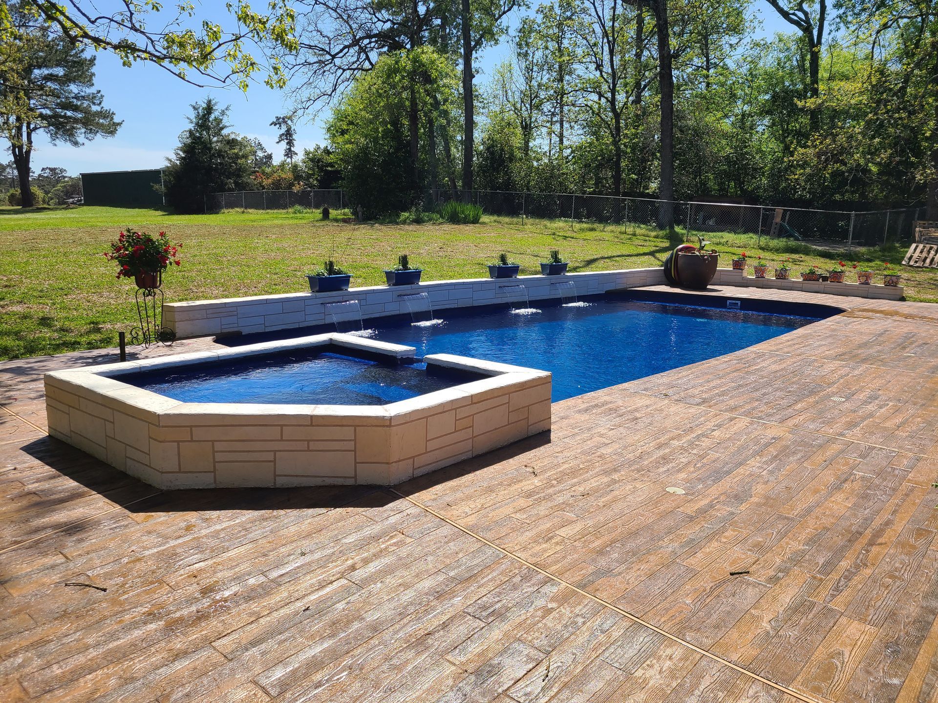 A large swimming pool with a hot tub in the middle of it.
