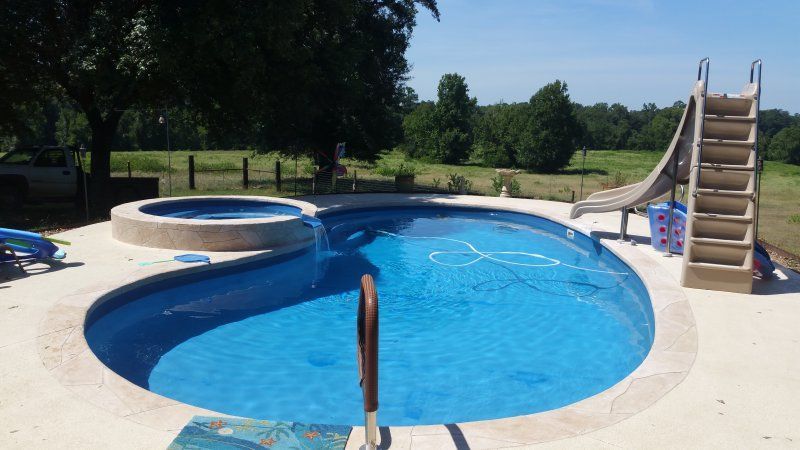 A large swimming pool with a slide and stairs