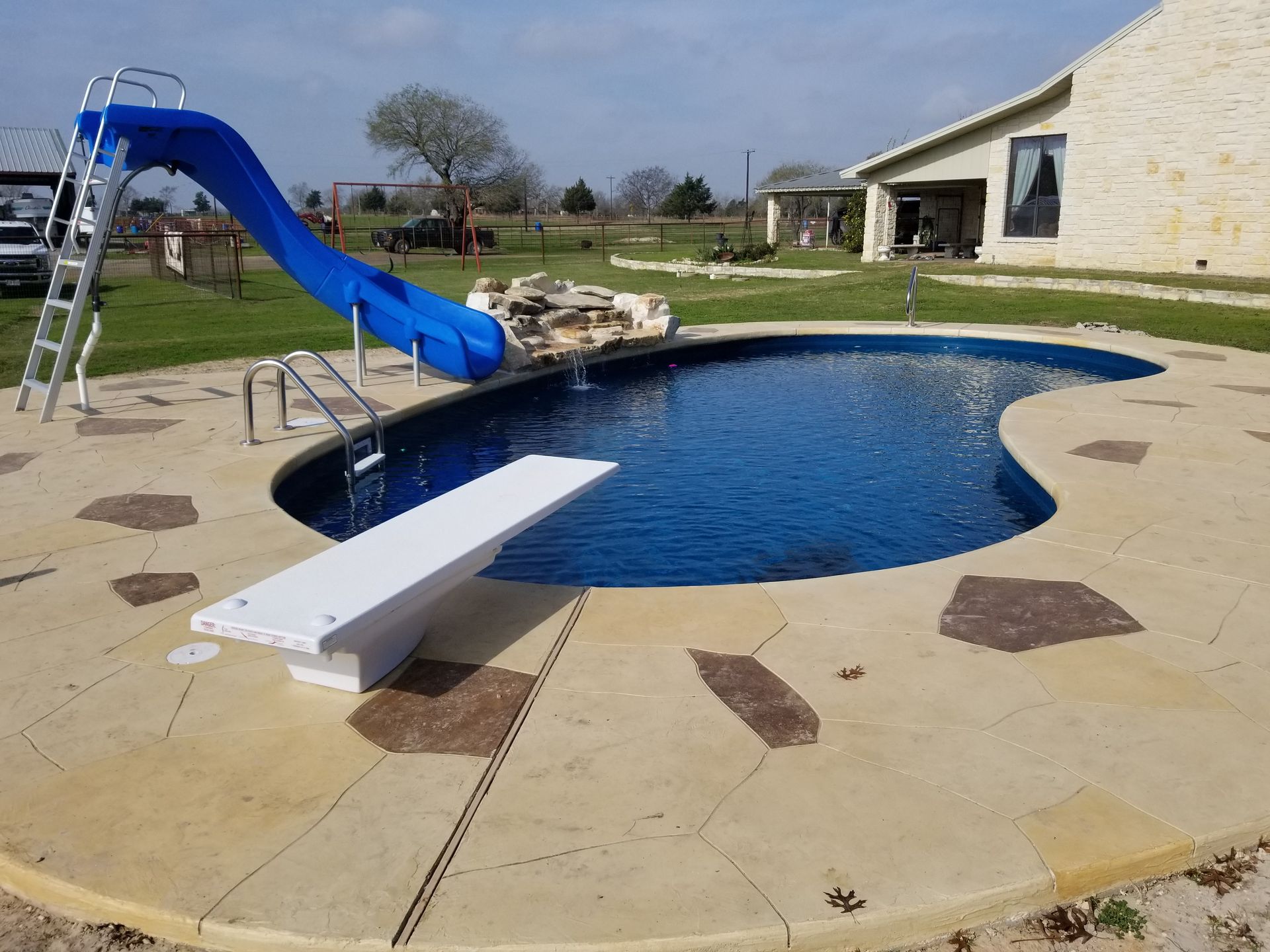 A swimming pool with a blue slide and diving board