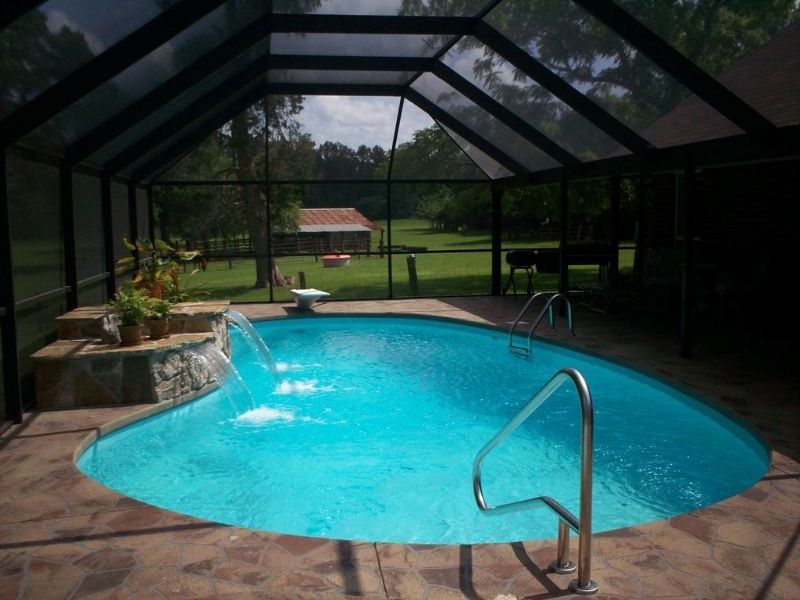 A swimming pool inside of a screened in area