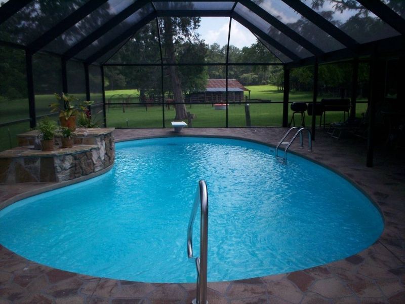A swimming pool inside of a screened in area
