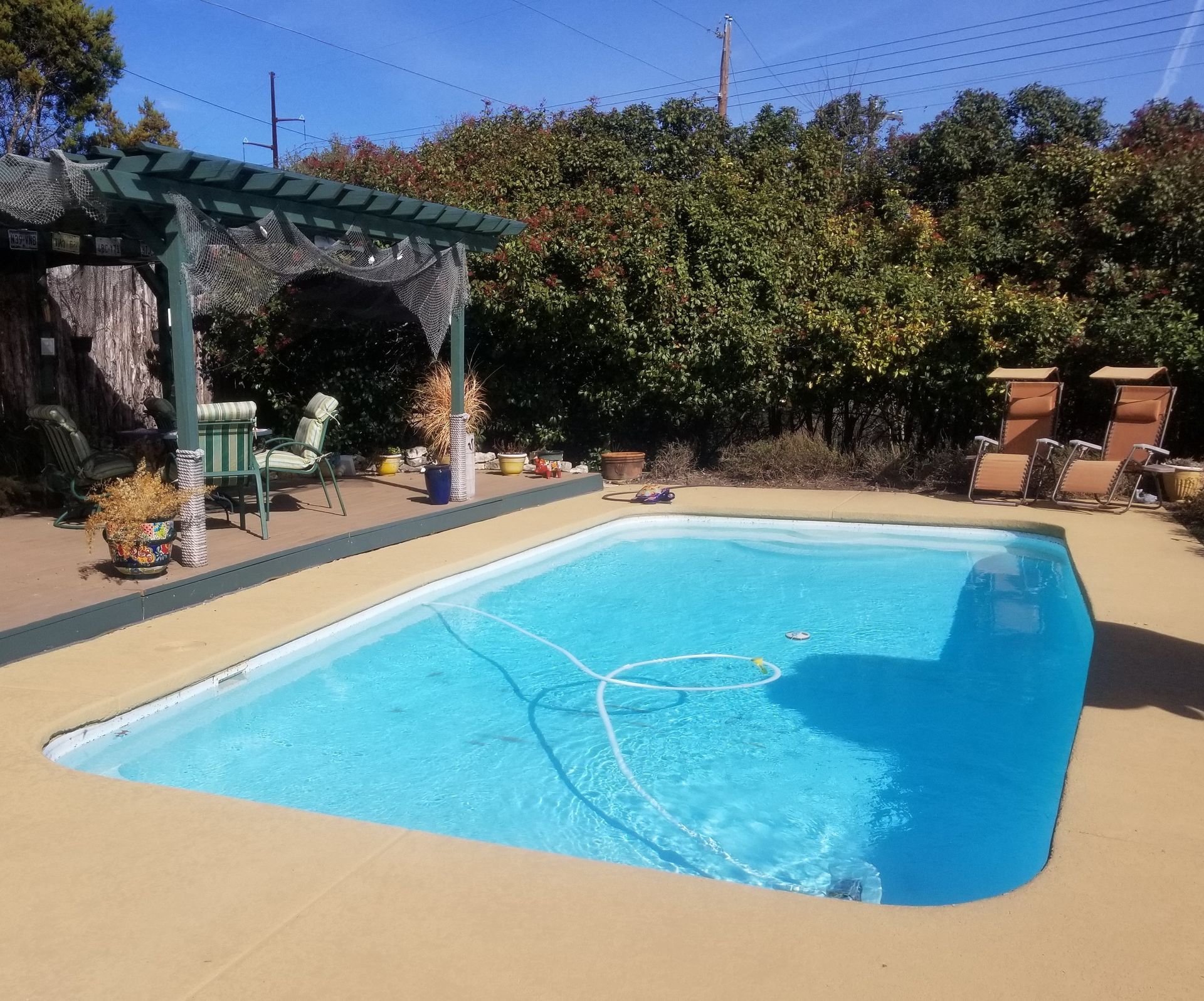 A large swimming pool with a fence in the background.