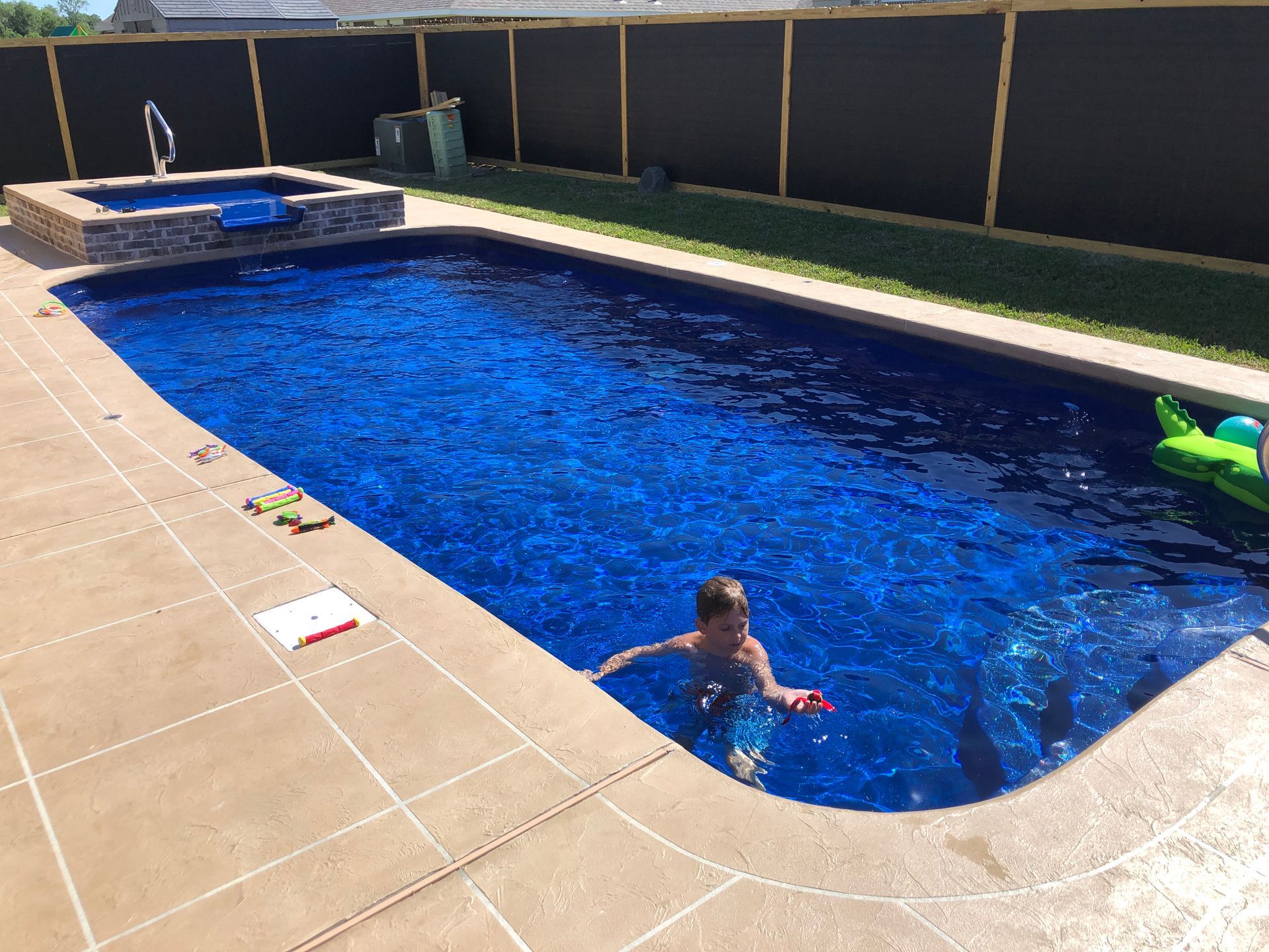 A boy is swimming in a large swimming pool.