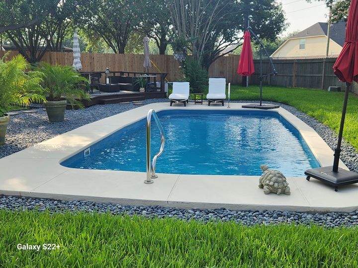 A turtle is sitting on the edge of a swimming pool.