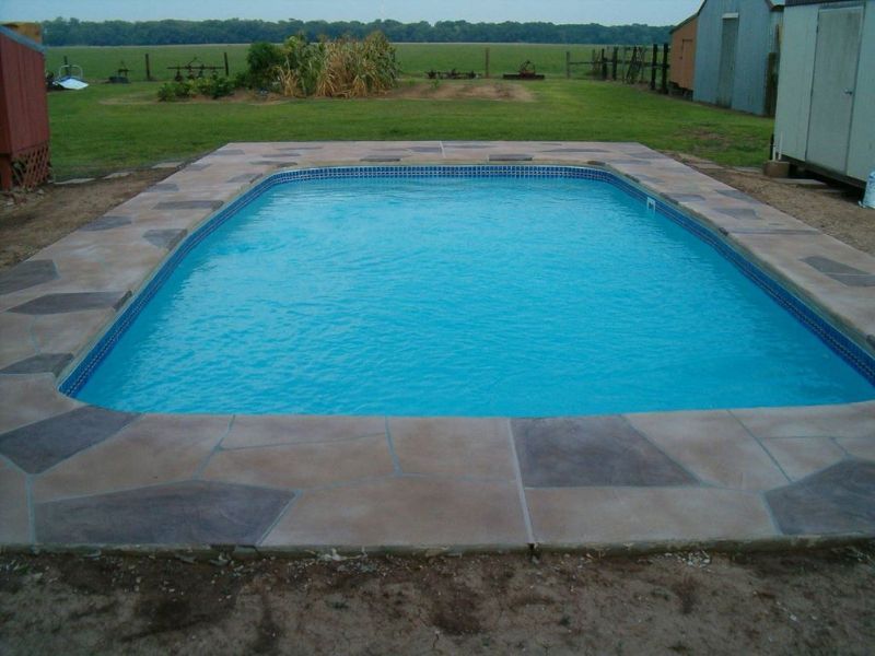 A large swimming pool with a fence in the background