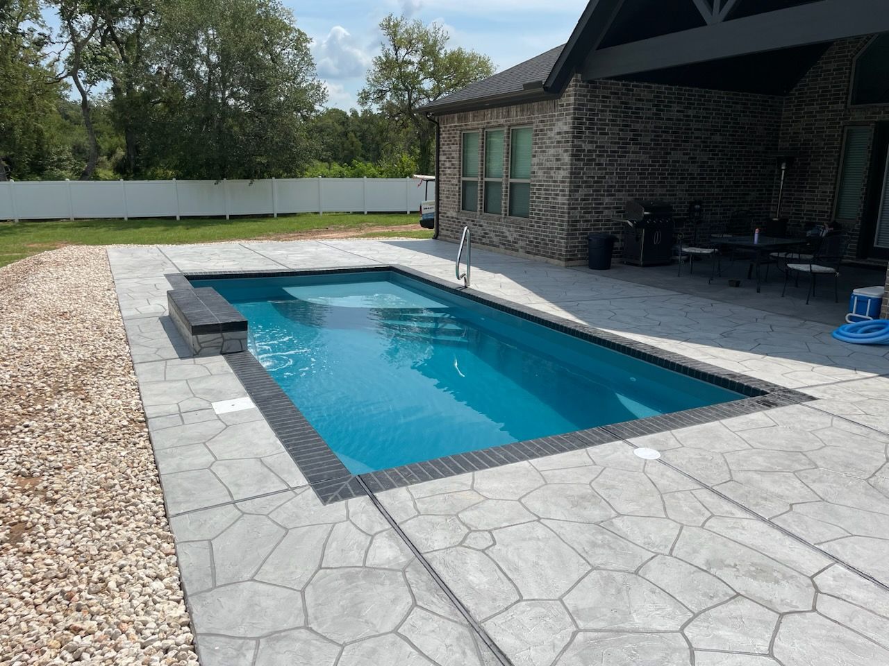 A small swimming pool is on a wooden deck