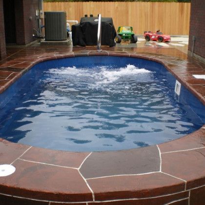 A swimming pool with blue water and a fence in the background