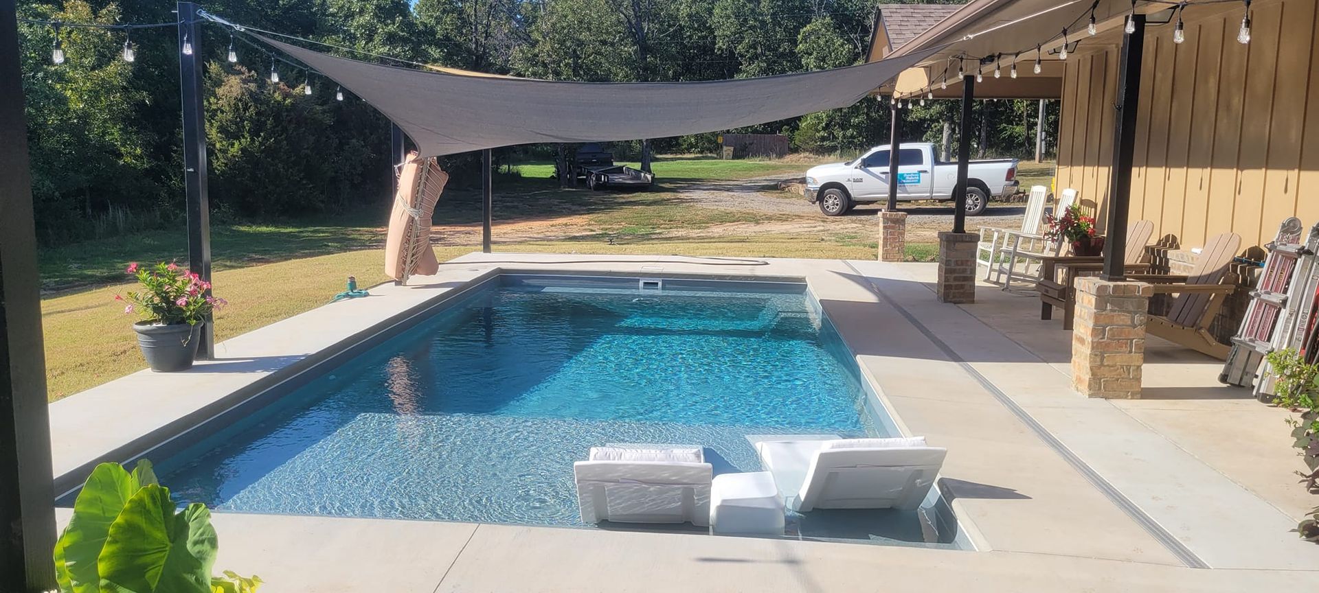 A swimming pool with a staircase leading to it in a backyard