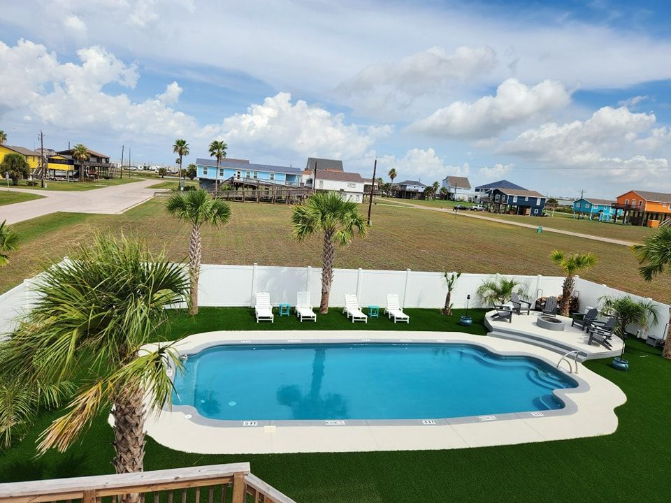 An aerial view of a large swimming pool surrounded by palm trees