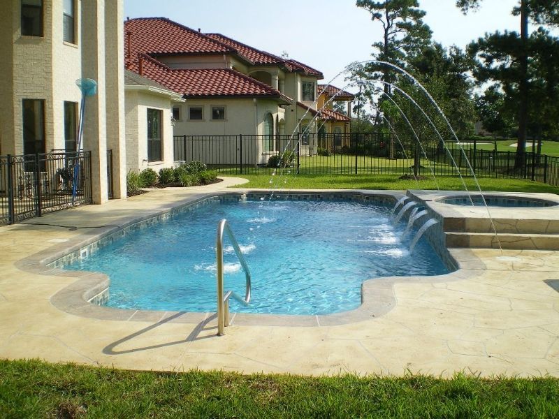 A large swimming pool in front of a large house
