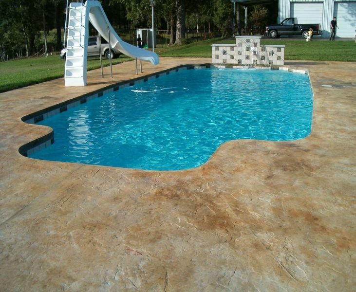 A large swimming pool with a slide in the backyard