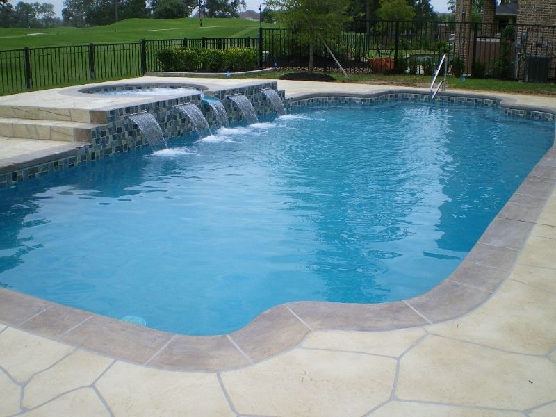 A large swimming pool with a waterfall in the middle