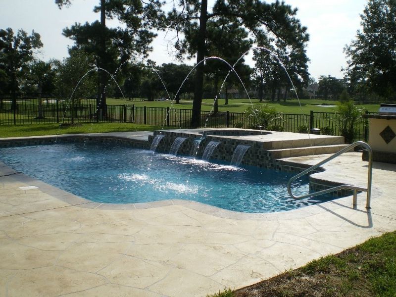 A large swimming pool with a waterfall in the middle