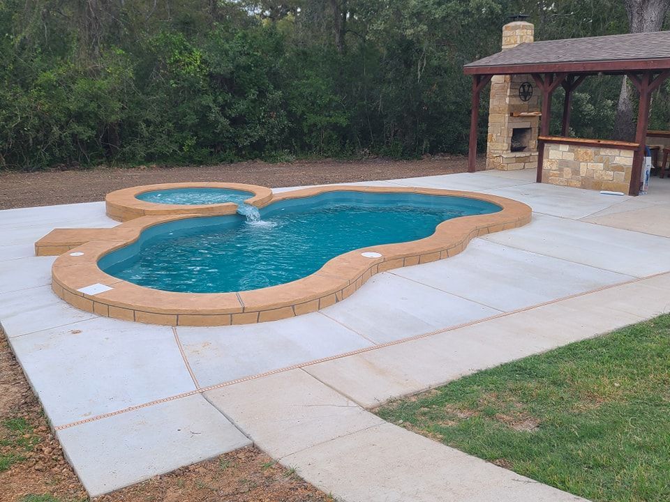 A large swimming pool with a gazebo in the background