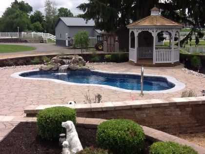 A large swimming pool with a gazebo in the background