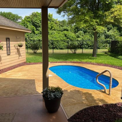 A small swimming pool in the backyard of a house