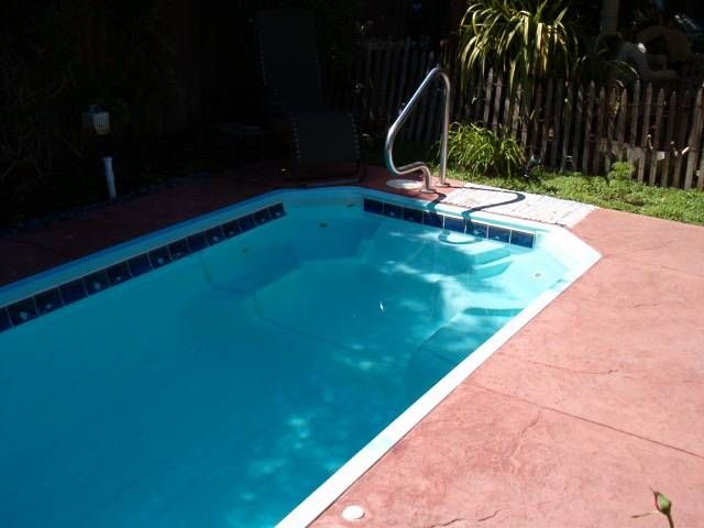 A swimming pool with a fence in the background