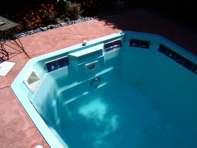 A blue swimming pool is sitting on a patio