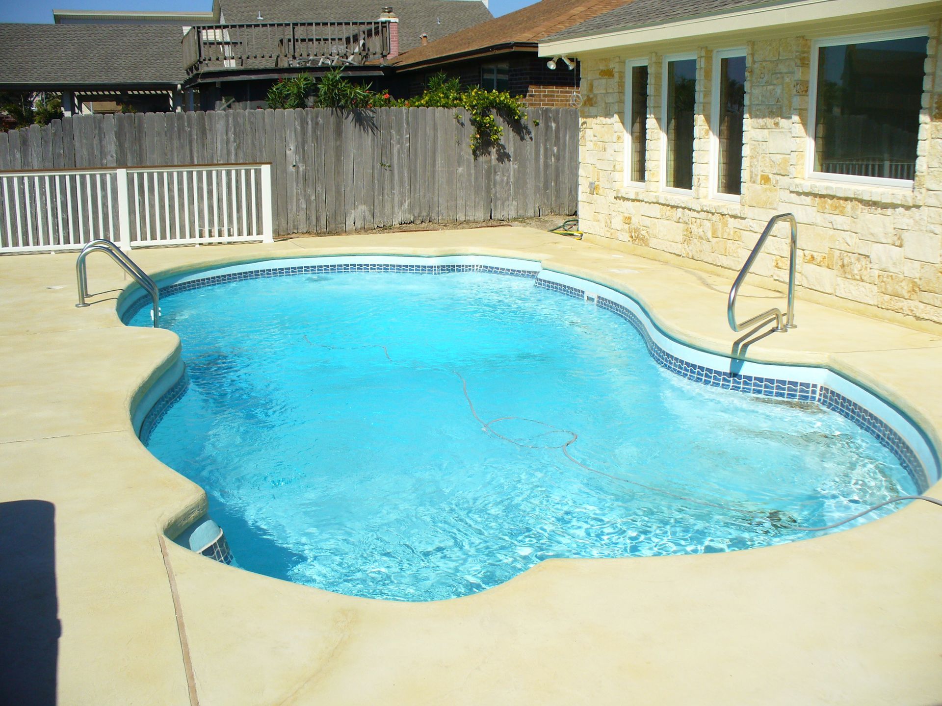 A large swimming pool in the backyard of a house