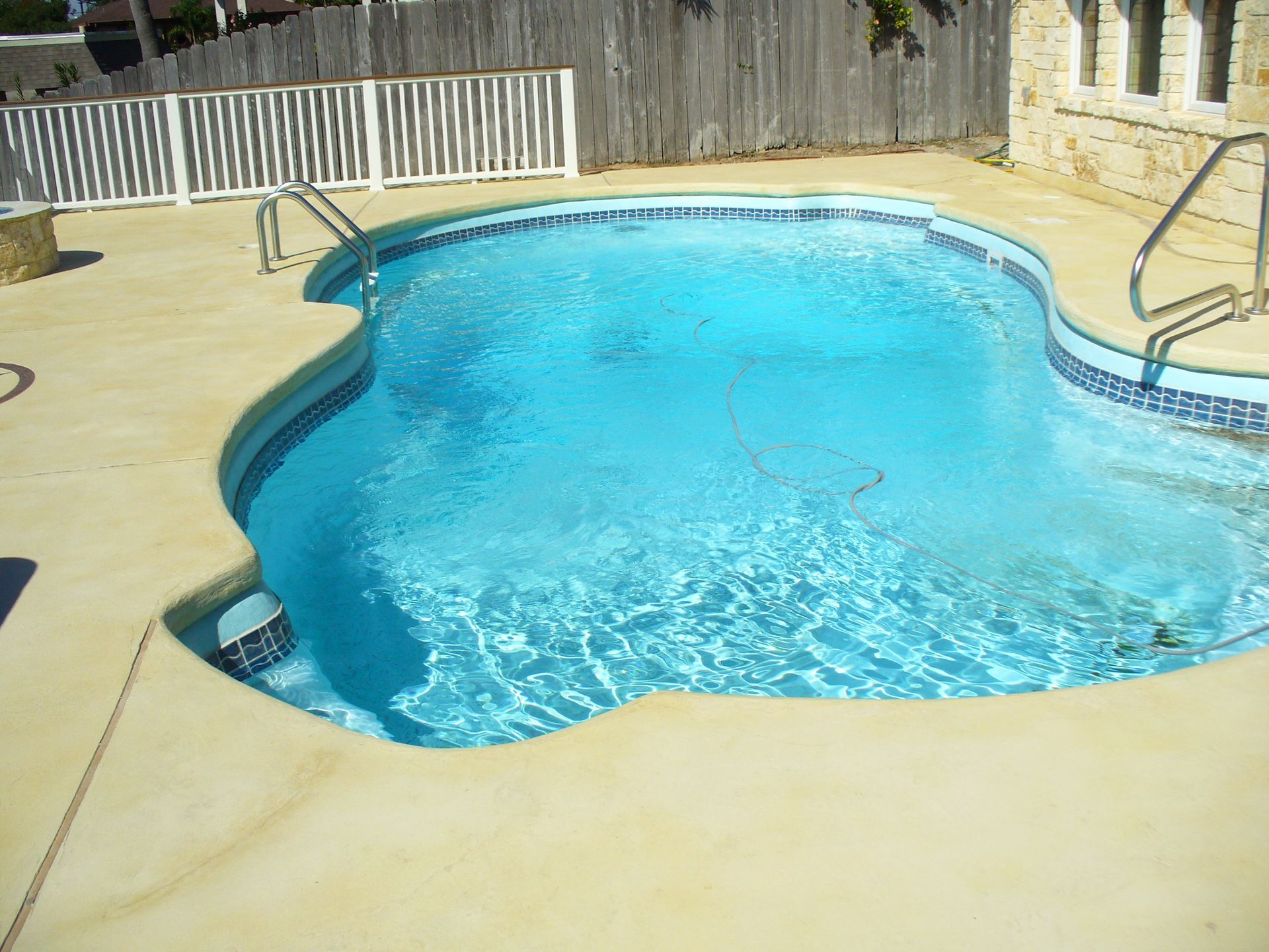 A large swimming pool with a fence in the background