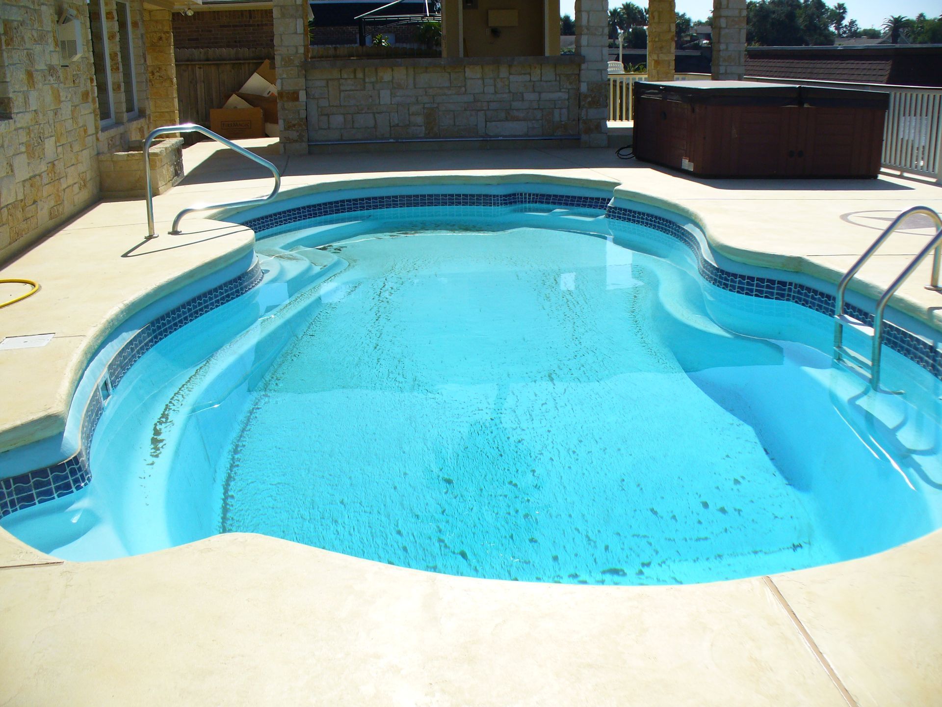 A large swimming pool with a hot tub in the middle