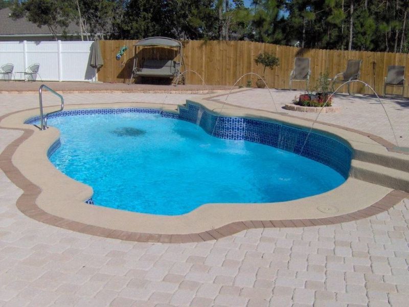A large swimming pool with a wooden fence in the background