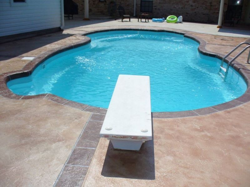 A swimming pool with a diving board in the middle