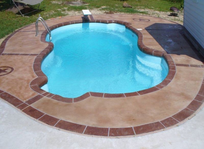 A swimming pool is surrounded by a concrete deck