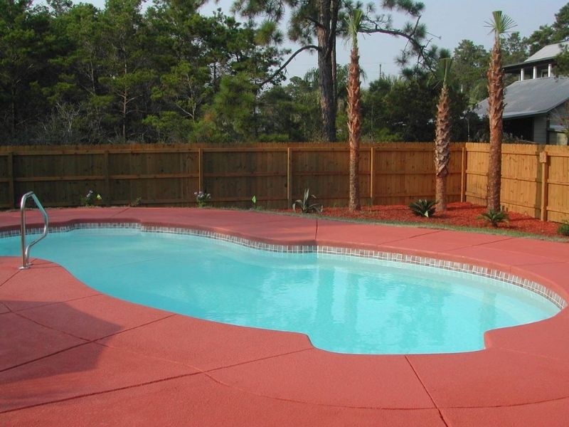 A large swimming pool with a wooden fence surrounding it