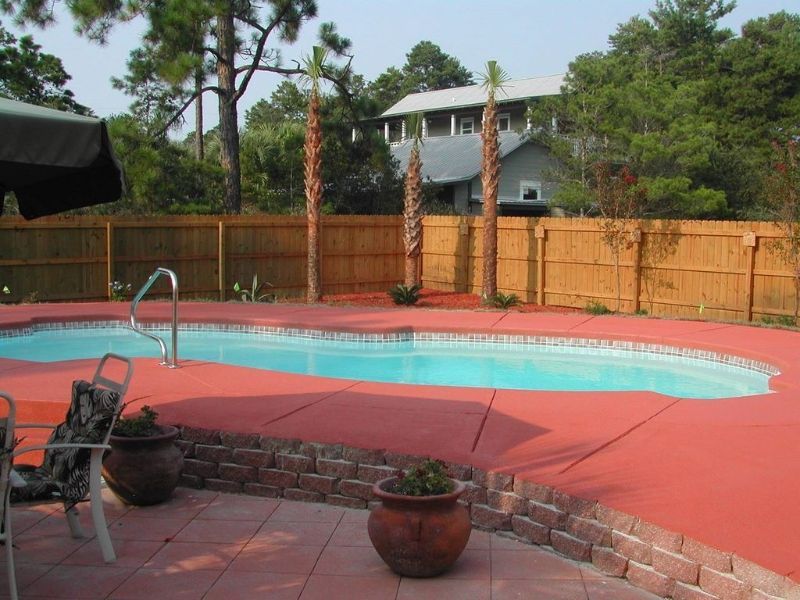 A large swimming pool with a wooden fence around it