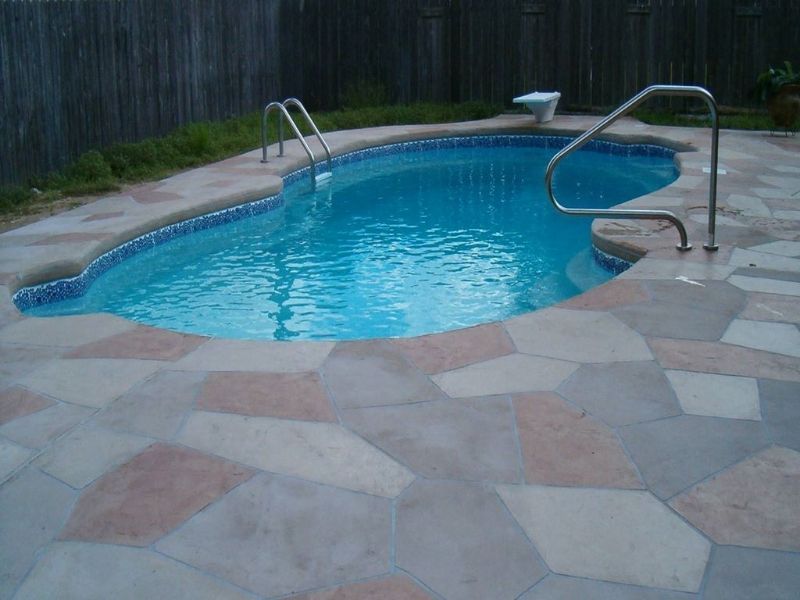 A large swimming pool with a fence in the background