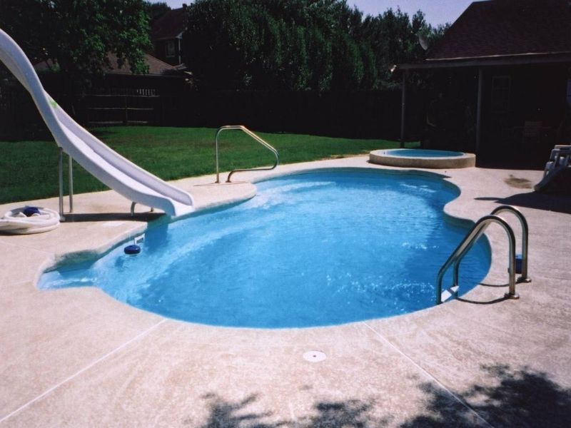 A swimming pool with a slide in the backyard