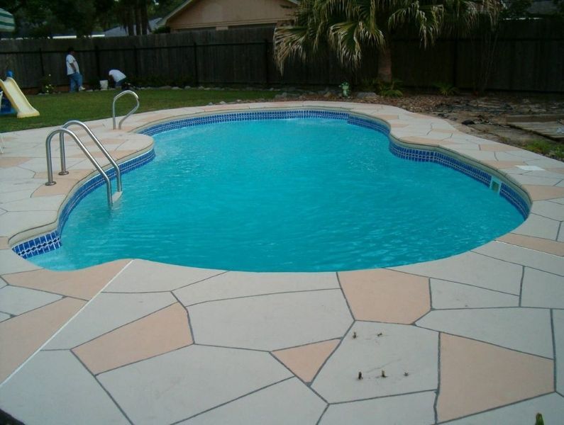 A large swimming pool with a slide in the background