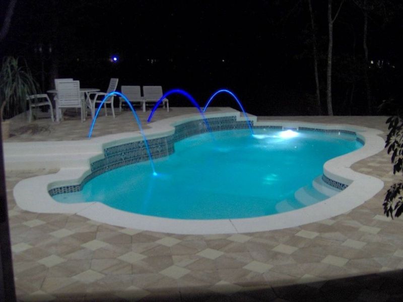 A large swimming pool is lit up at night