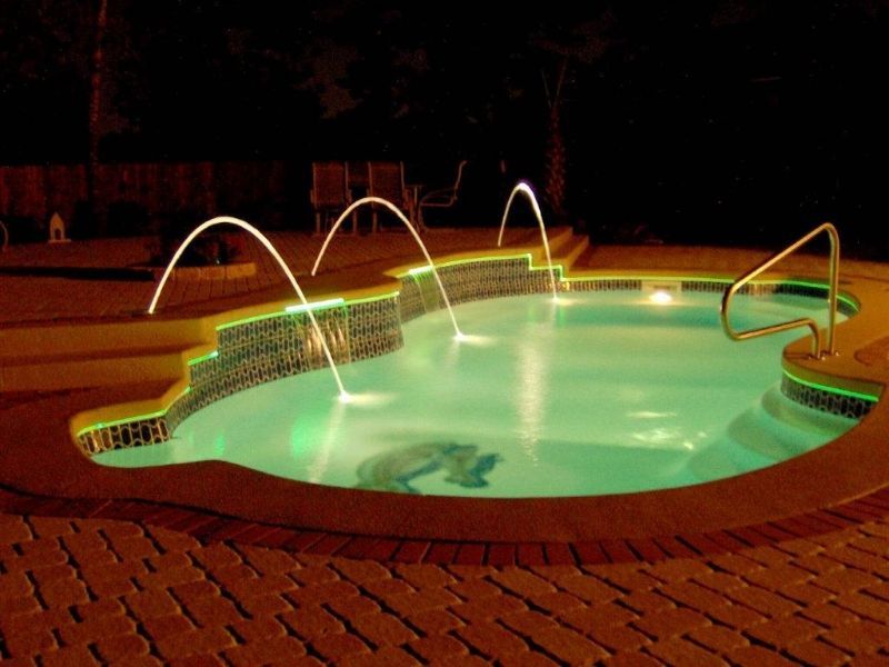 A large swimming pool is lit up at night
