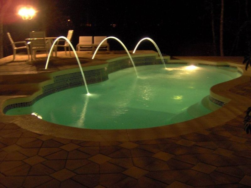 A large swimming pool is lit up at night
