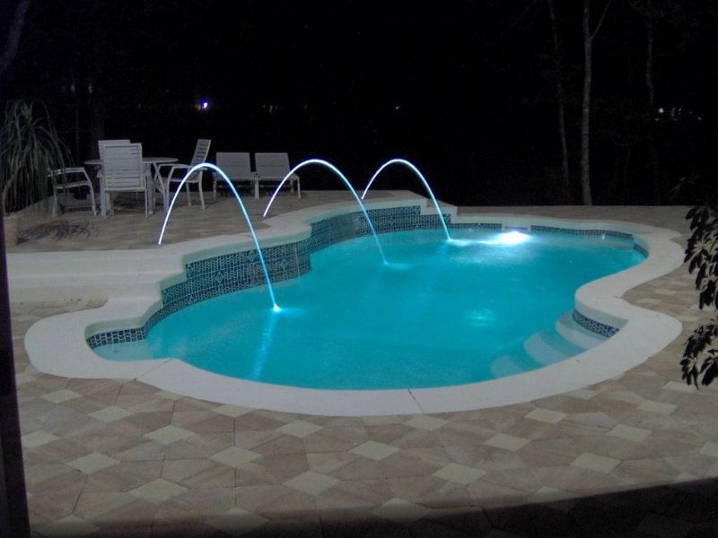 A large swimming pool is lit up at night