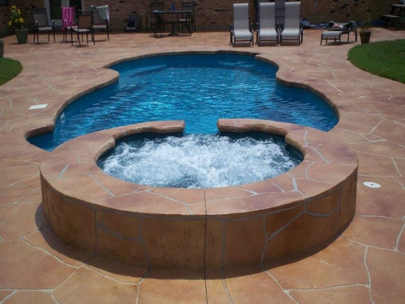 A large swimming pool with a hot tub in the middle