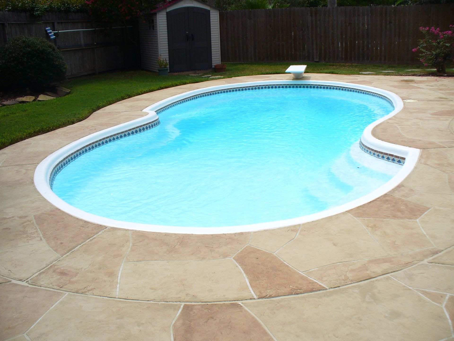 A swimming pool with a shed in the background