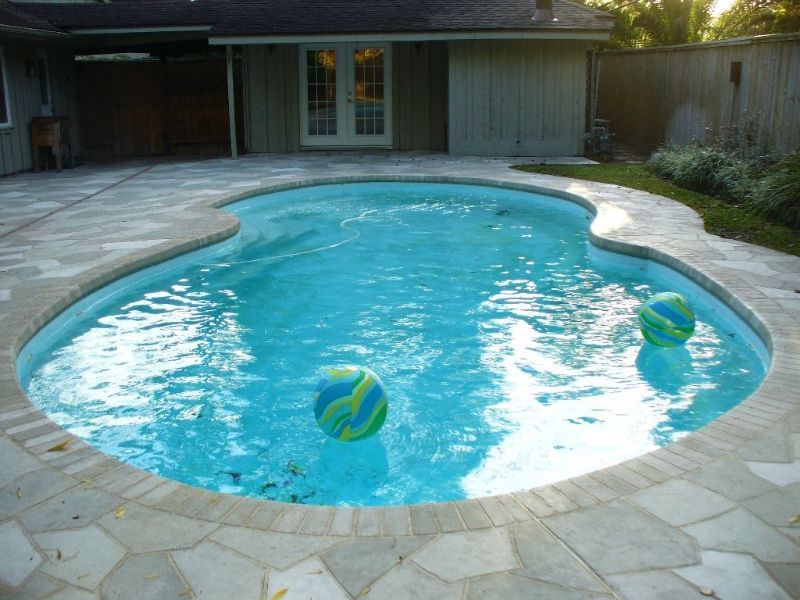 A swimming pool with two beach balls in it