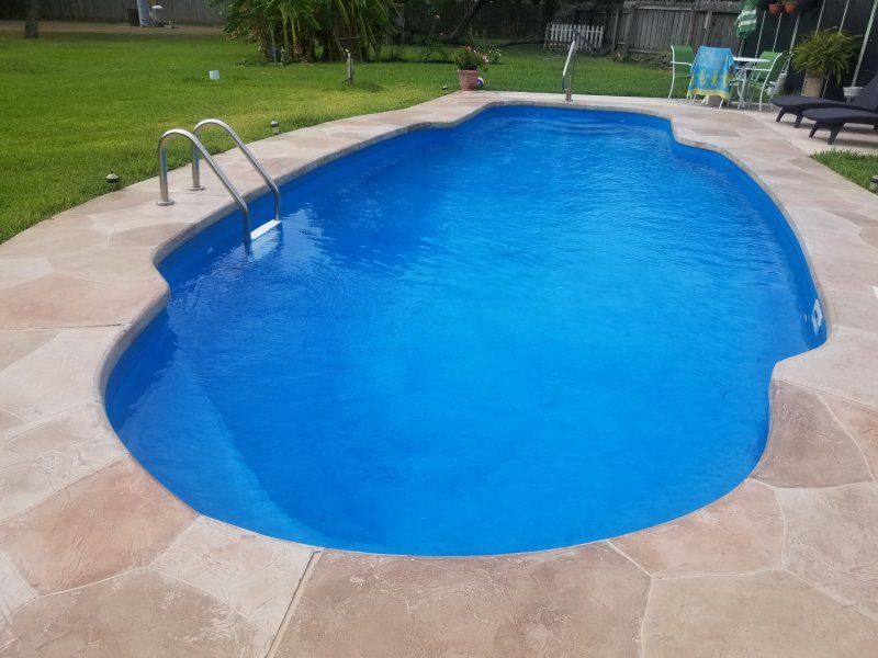 A large blue swimming pool with stairs leading to it