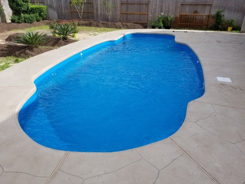 A large blue swimming pool with a fence in the background